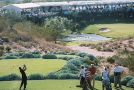 Golfer teeing off while spectators watch
