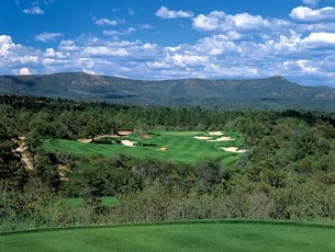 Golf course fairway with bunkers and mountains