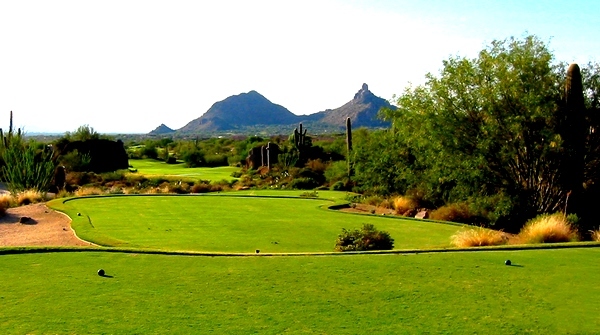 Desert golf course with distant mountain peaks